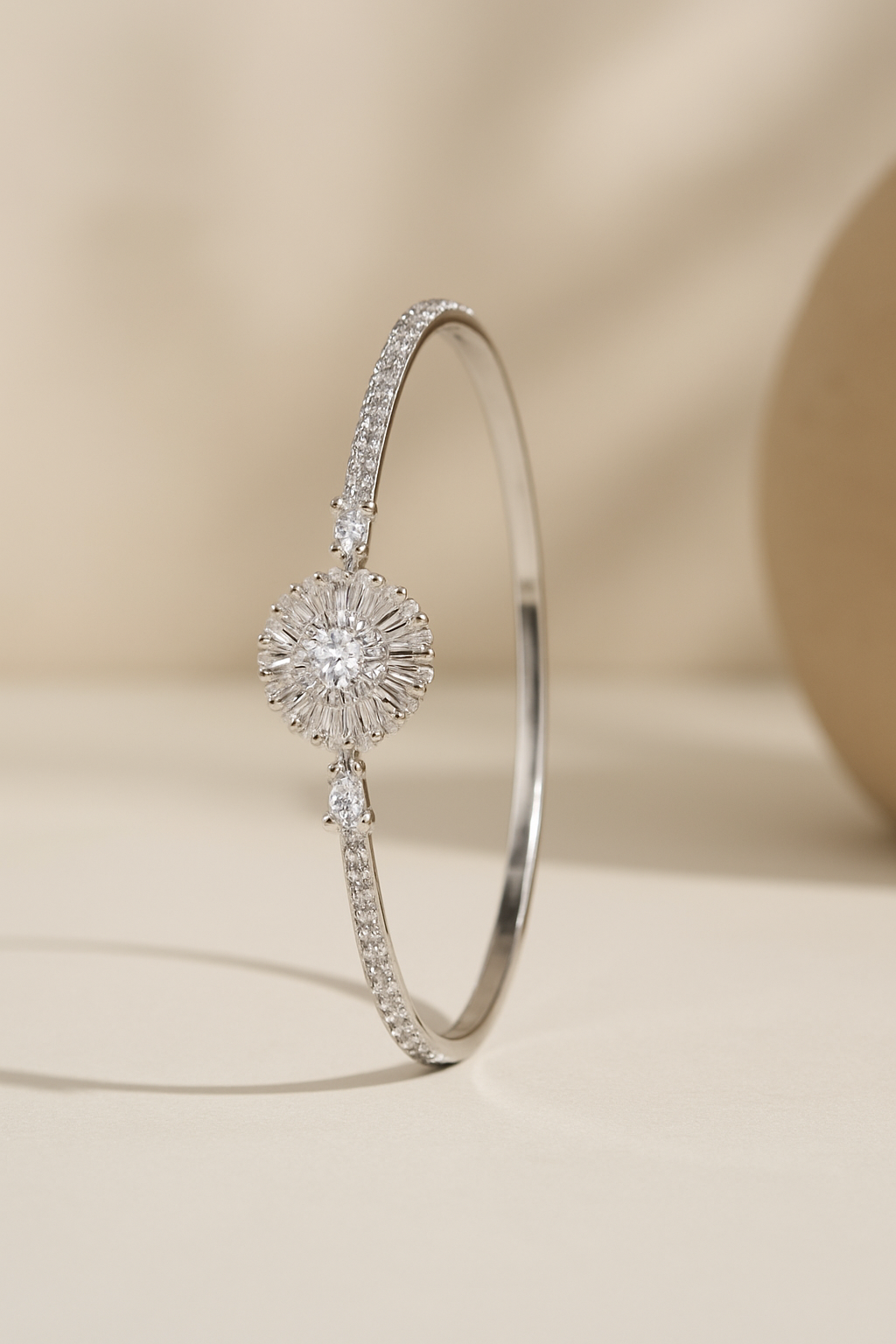 Silver bracelet with a central diamond and smaller stones on a beige background