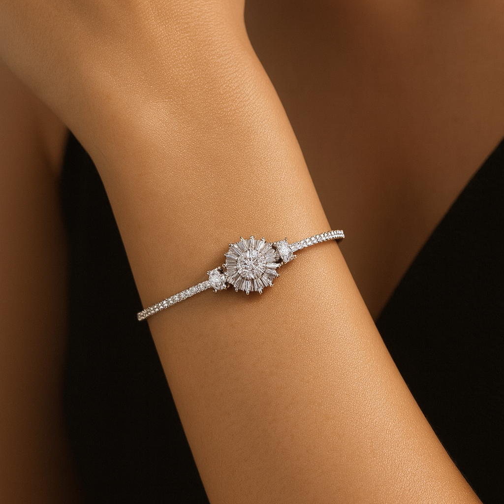 Silver bracelet with a floral design on a person's wrist against a blurred background