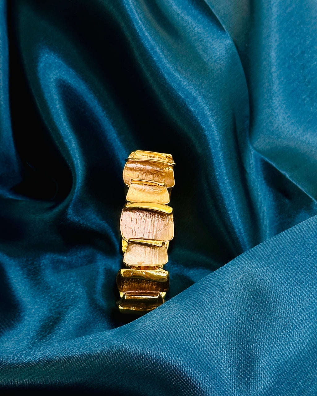 Gold bracelet on a blue satin background
