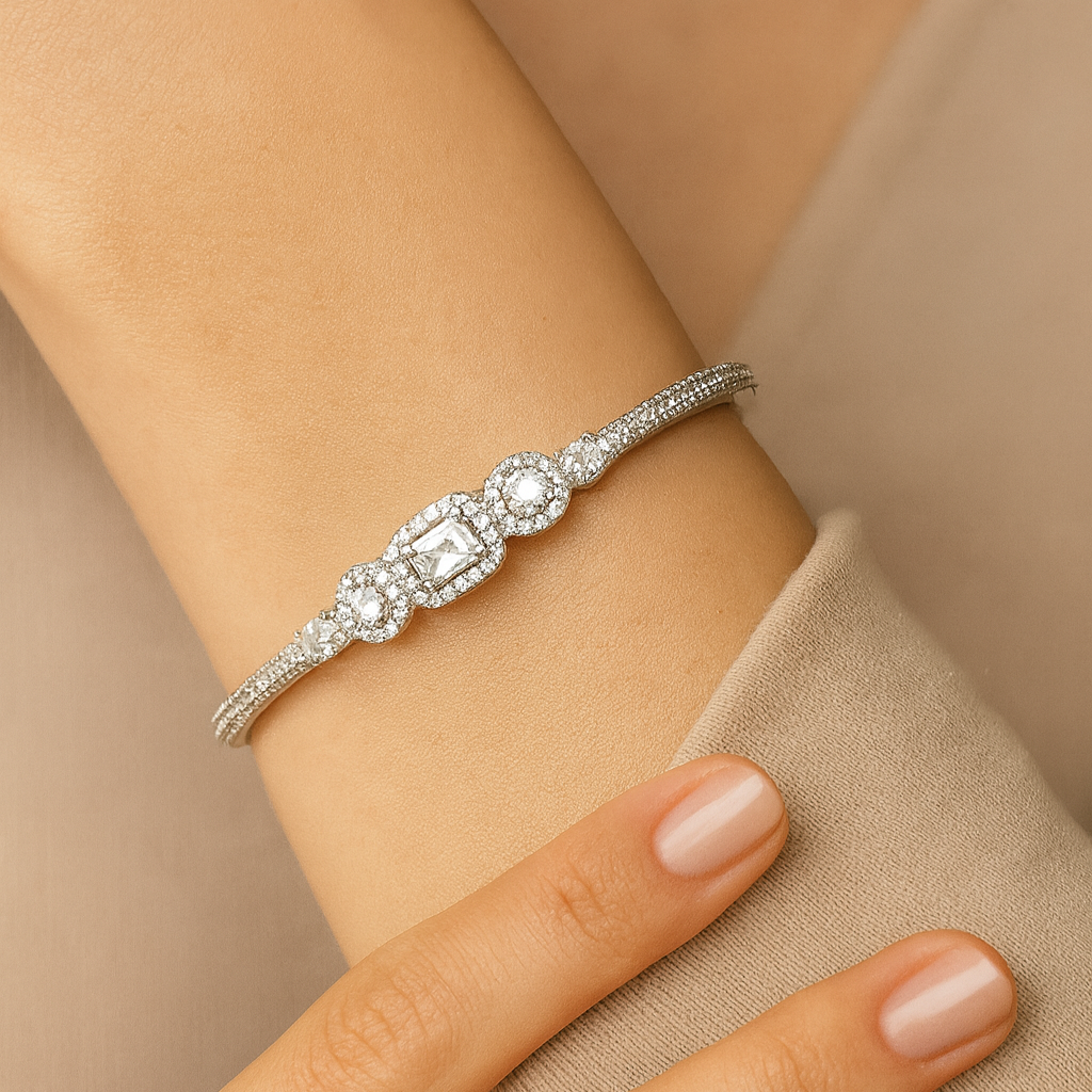 Silver bracelet with a large central gemstone on a wrist against a beige background